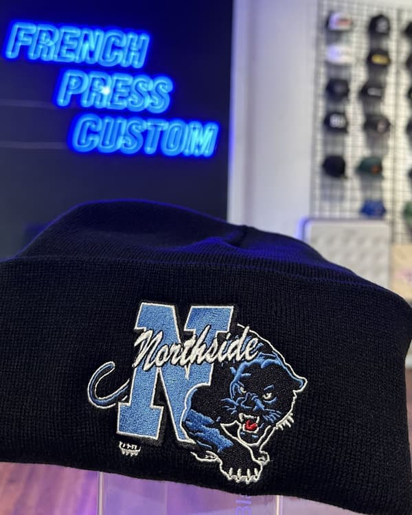 Full-color mascot embroidery on a navy cuffed knit beanie