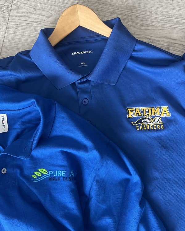 School mascot and multi-color corporate logos stitched on royal performance polos